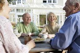 Seniors socializing around a table outside