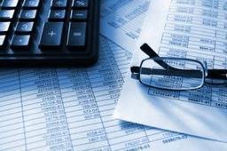 Calculator, glasses and financial sheets