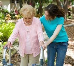 A caregiver walking outside with an older woman