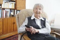 Older woman sitting in a plush chair and smiling